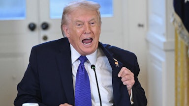 Donald Trump, sitting, speaks vehemently with wide-open mouth