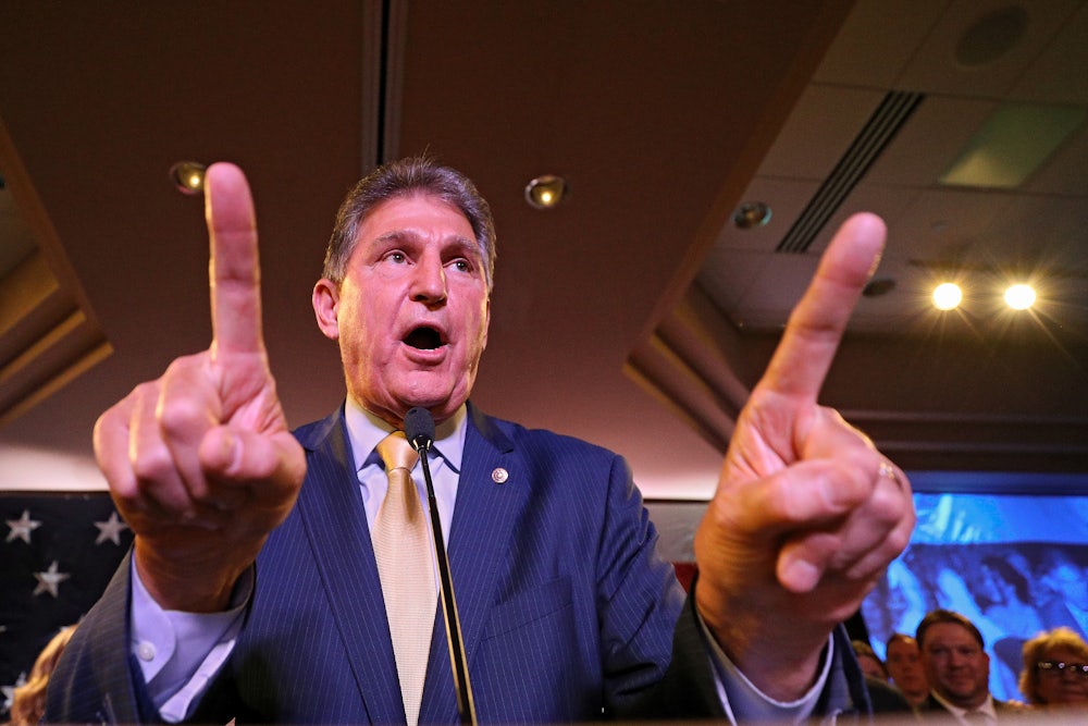 Senator Joe Manchin gesticulates enthusiastically at a gathering of voters.