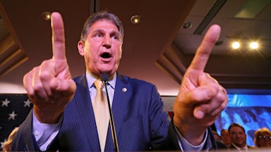 Senator Joe Manchin gesticulates enthusiastically at a gathering of voters.