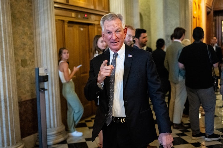 Senator Tommy Tuberville points a finger at the camera as he walks in the Capitol.