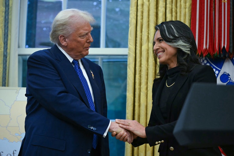 Donald Trump and Tulsi Gabbard shake hands while standing in the Oval Office