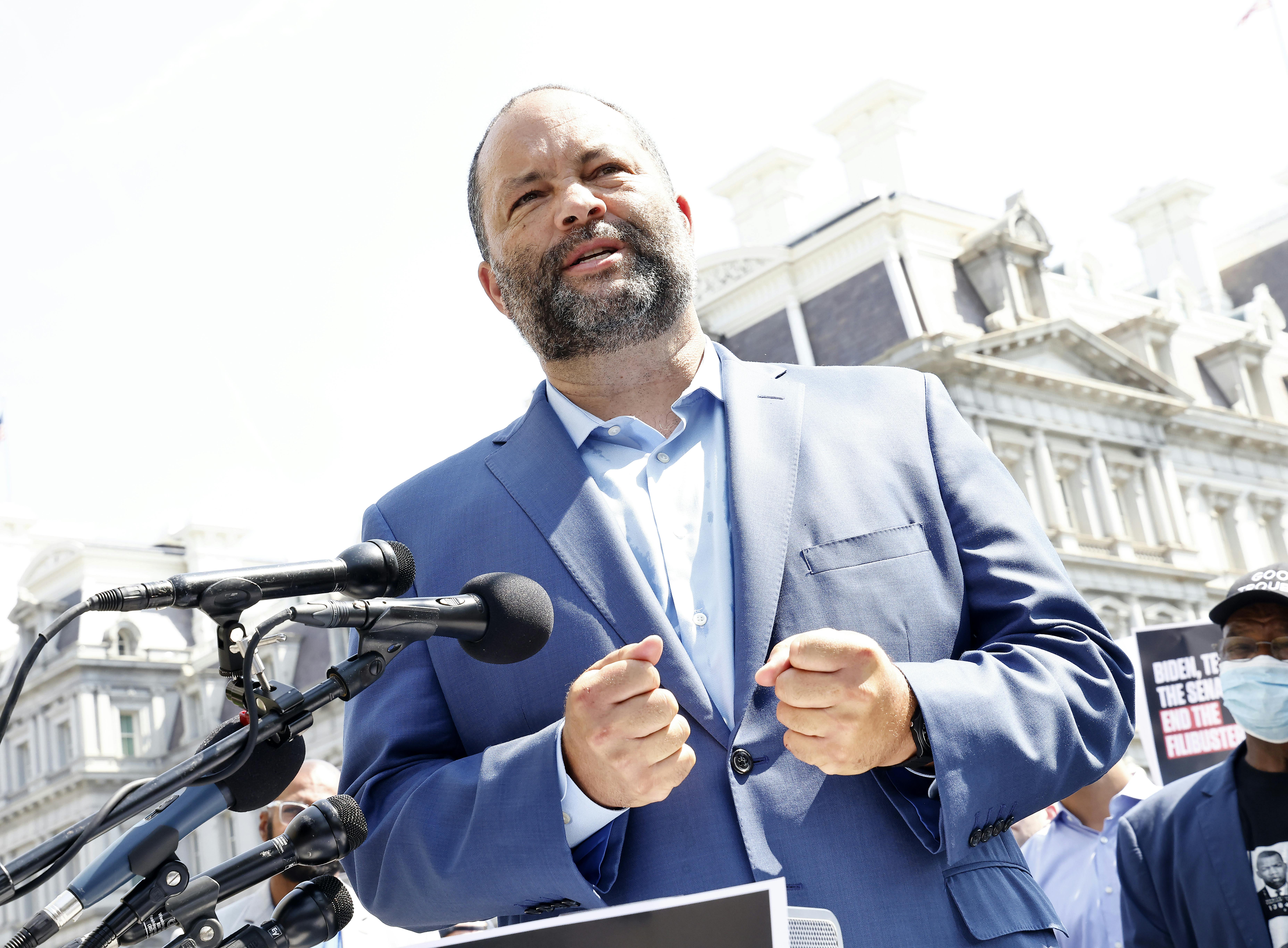 Ben Jealous stands in front of microphones.