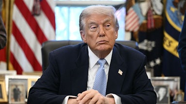 Donald Trump sits at his desk in the Oval Office of the White House.