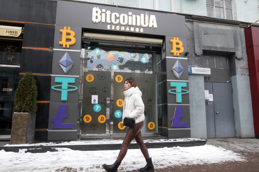A woman walks past a cryptocurrency exchange point in the center of Kyiv, Ukraine.