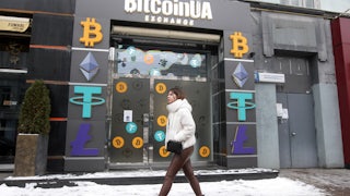 A woman walks past a cryptocurrency exchange point in the center of Kyiv, Ukraine.