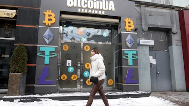 A woman walks past a cryptocurrency exchange point in the center of Kyiv, Ukraine.