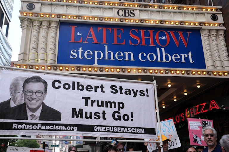 Dozens of anti-Trump protesters gather outside the Ed Sullivan Theater, home of The Late Show with Stephen Colbert, to protest CBS’s decision to fire the longtime host in July.
