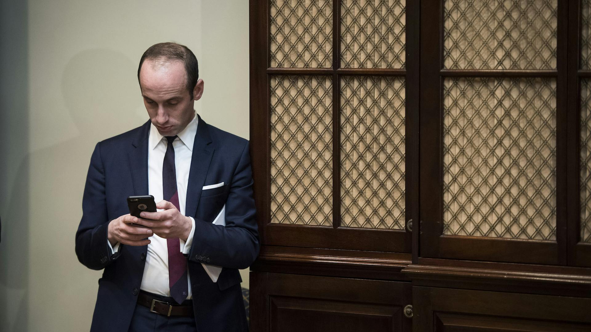 Stephen Miller looks at his phone