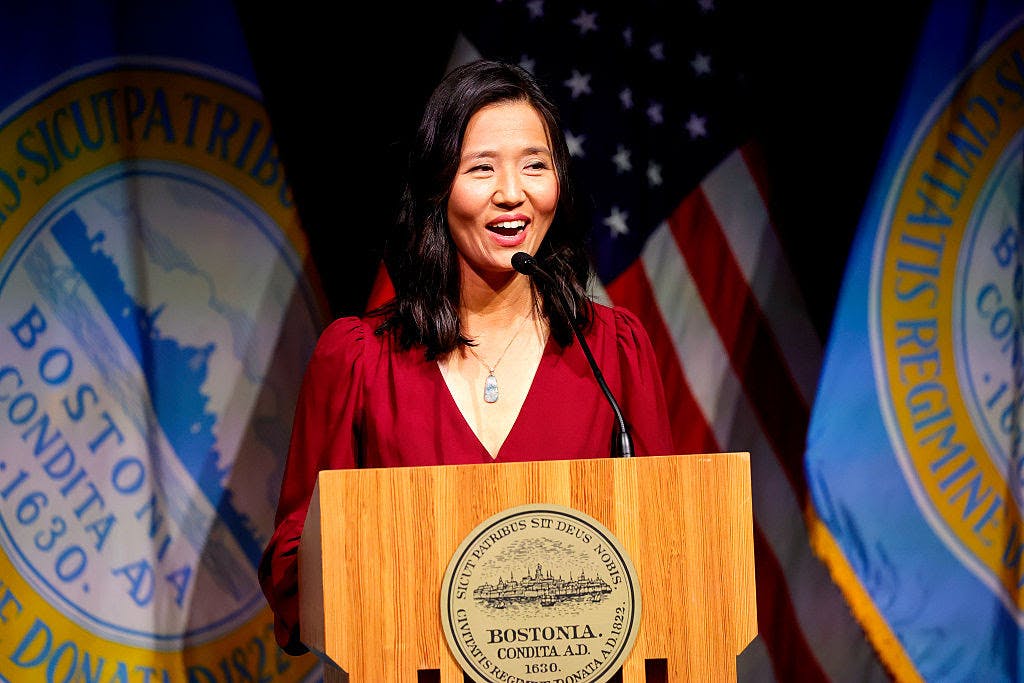 Michelle Wu, dressed in red, speaks at a podium.