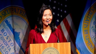 Michelle Wu, dressed in red, speaks at a podium.