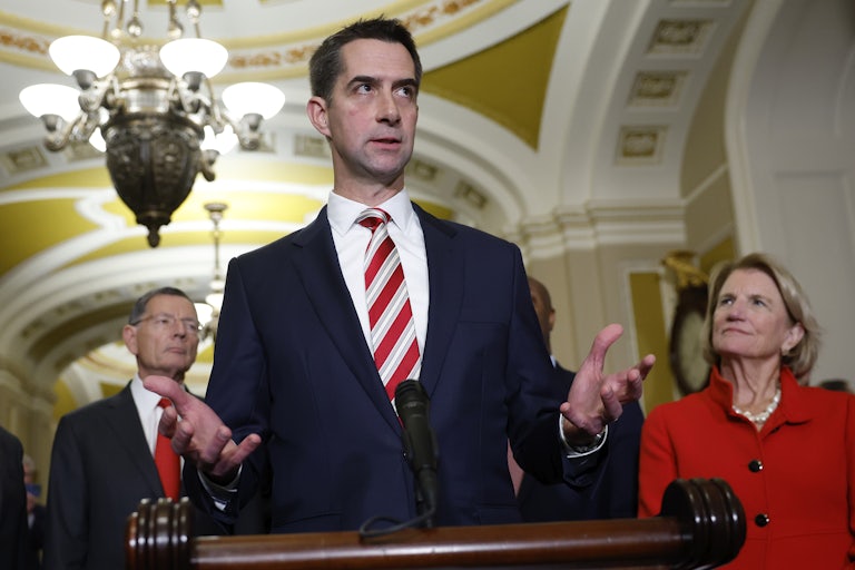 Tom Cotton stands at a podium and speaks to reporters