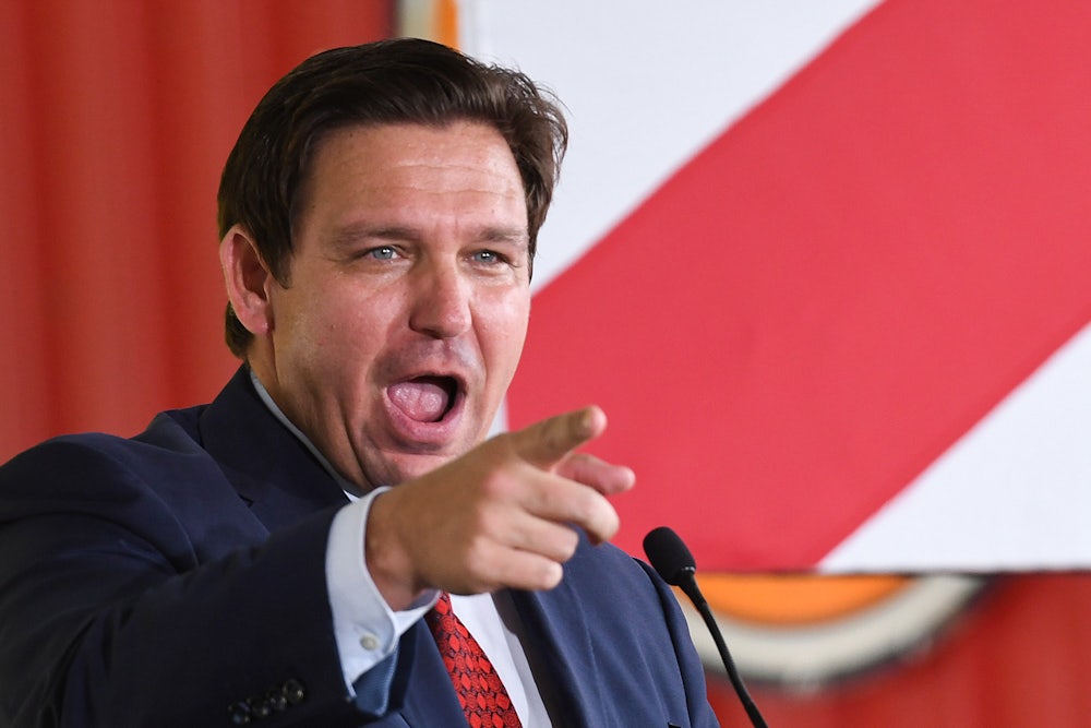Ron DeSantis points at something off-camera.