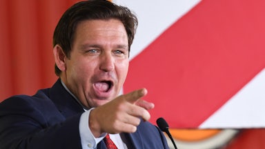 Ron DeSantis points at something off-camera.