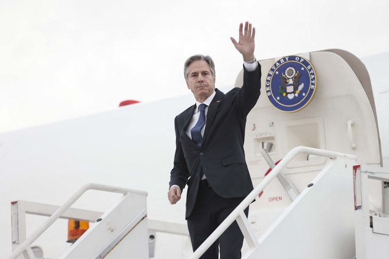 Secretary of State Antony Blinken greets the press while boarding a plane