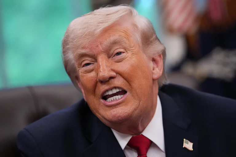 Donald Trump speaks while sitting at his desk in the Oval Office