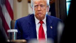 President Trump sits in a meeting in the Oval Office.