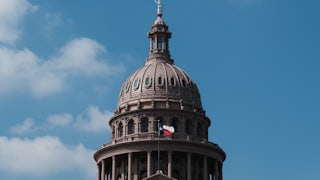 Texas state Capitol building with the state flag flying.