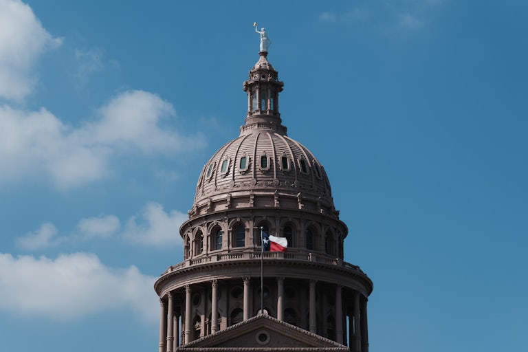 Texas state Capitol building with the state flag flying.