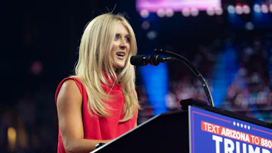 Riley Gaines speaks at a podium with a "Trump-Vance" sign