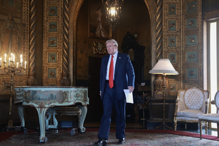 Donald Trump looks grim walking with papers in his hand at Mar-a-Lago.