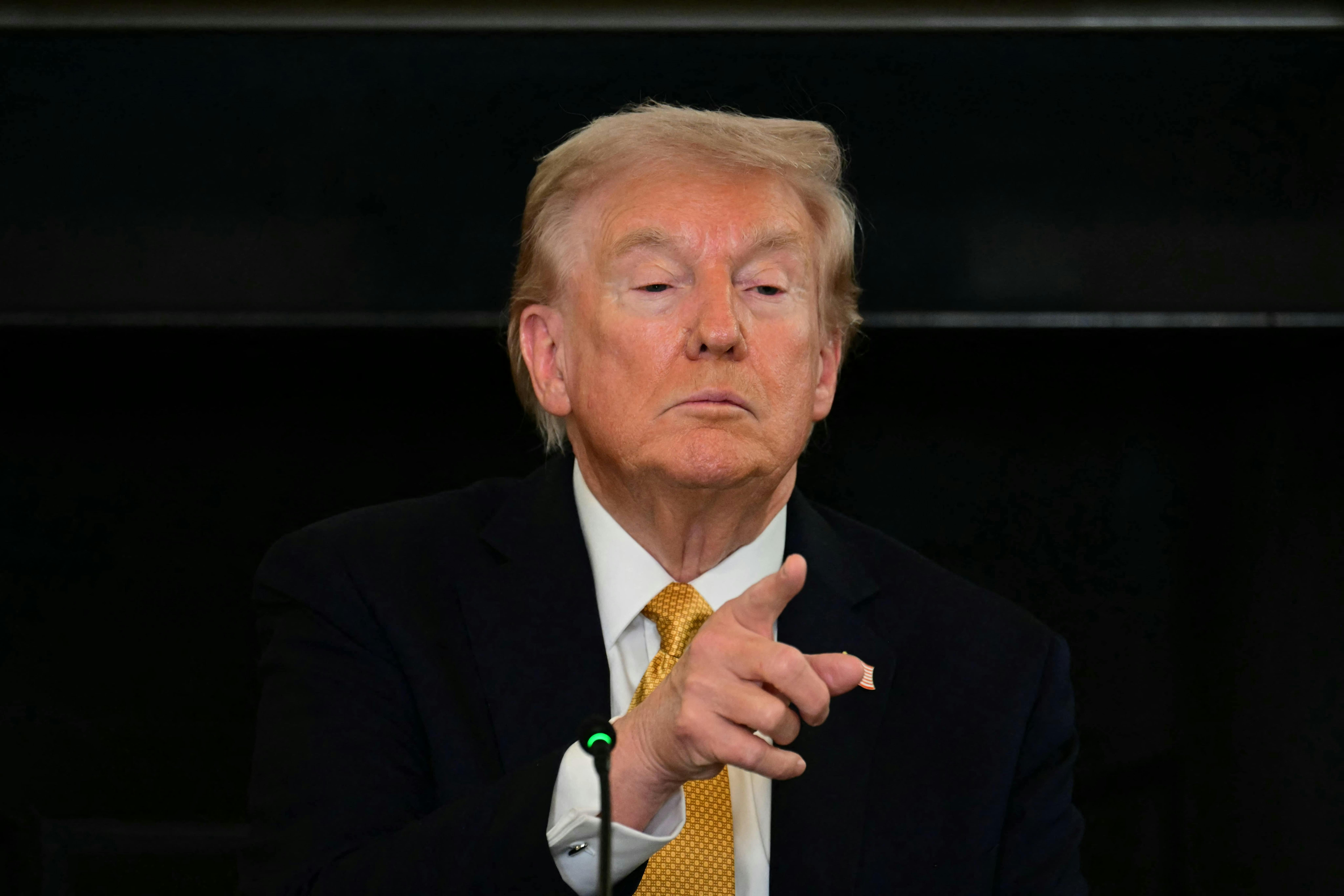 Donald Trump tilts his chin up as he points to a reporter (not pictured).