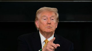 Donald Trump tilts his chin up as he points to a reporter (not pictured).