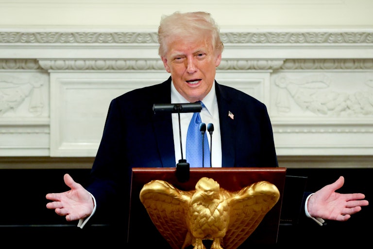 Donald Trump gestures while speaking at a podium