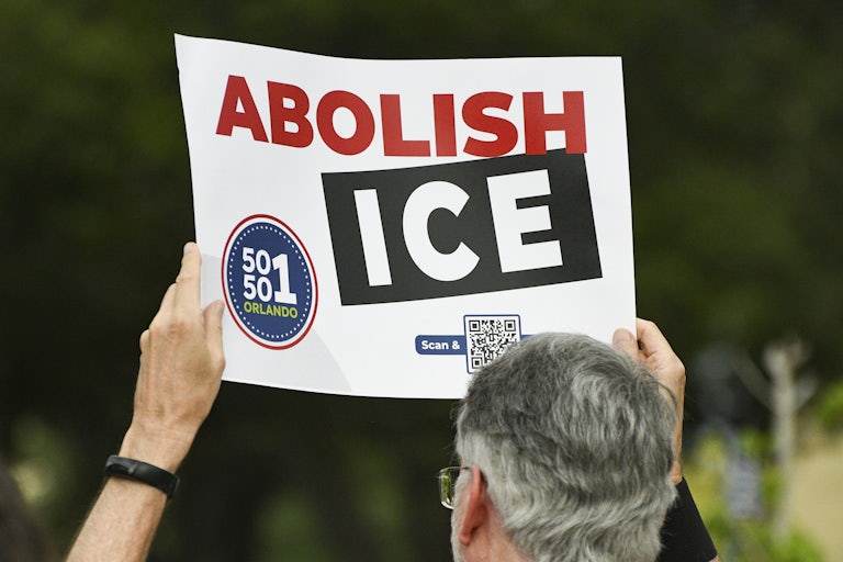 A person holds up a sign that says, "Abolish ICE" at a protest in Orlando, Florida