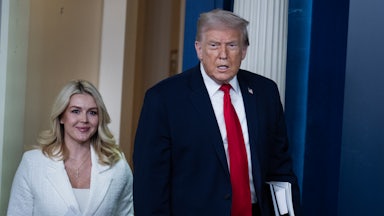 Karoline Leavitt walks behind Donald Trump as he enters the White House press briefing room