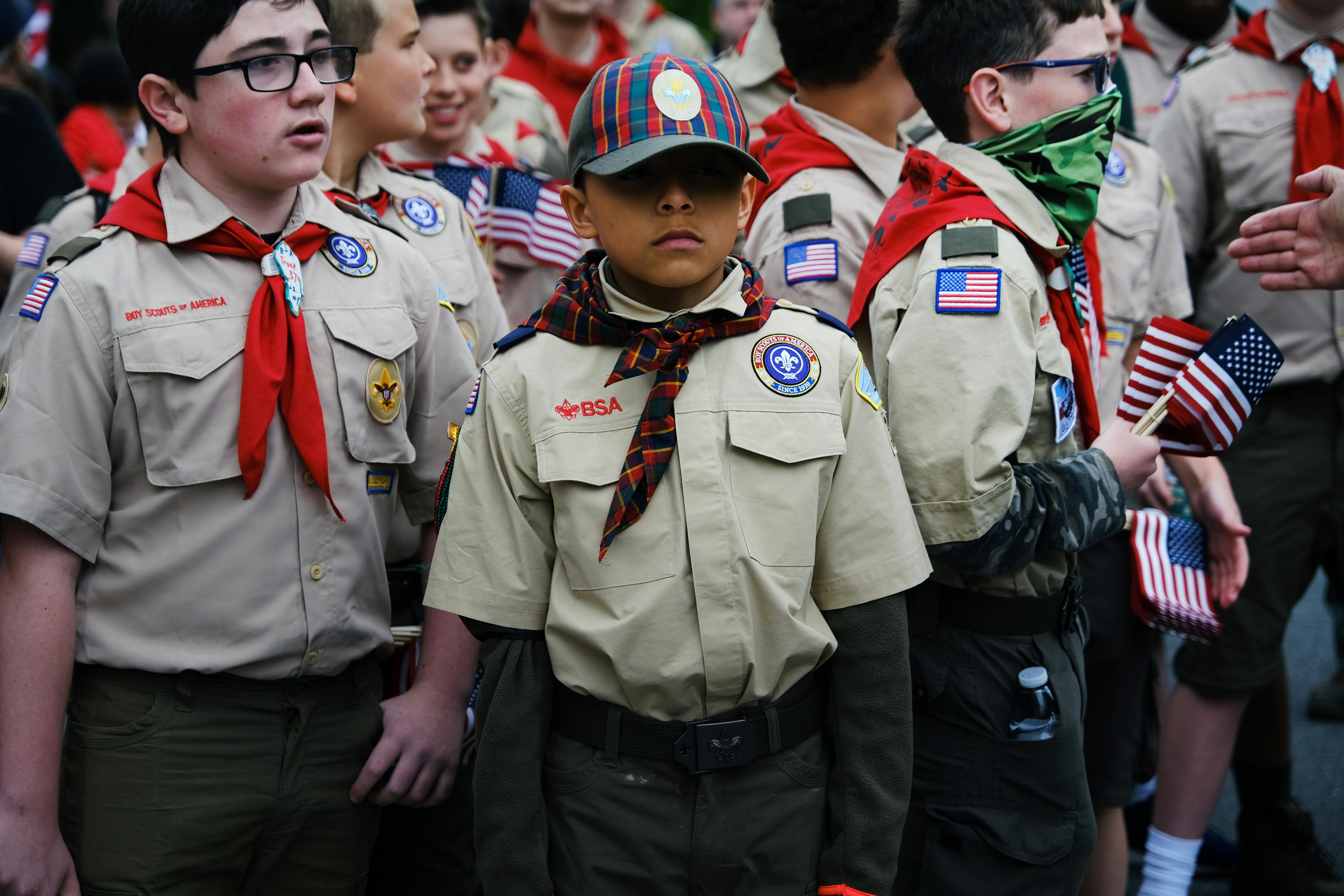 A bunch of boy Scouts holding American flags.