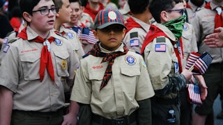 A bunch of boy Scouts holding American flags.