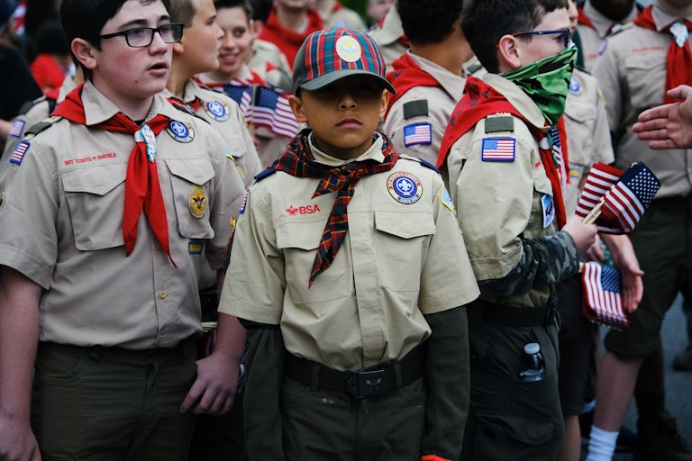 A bunch of boy Scouts holding American flags.