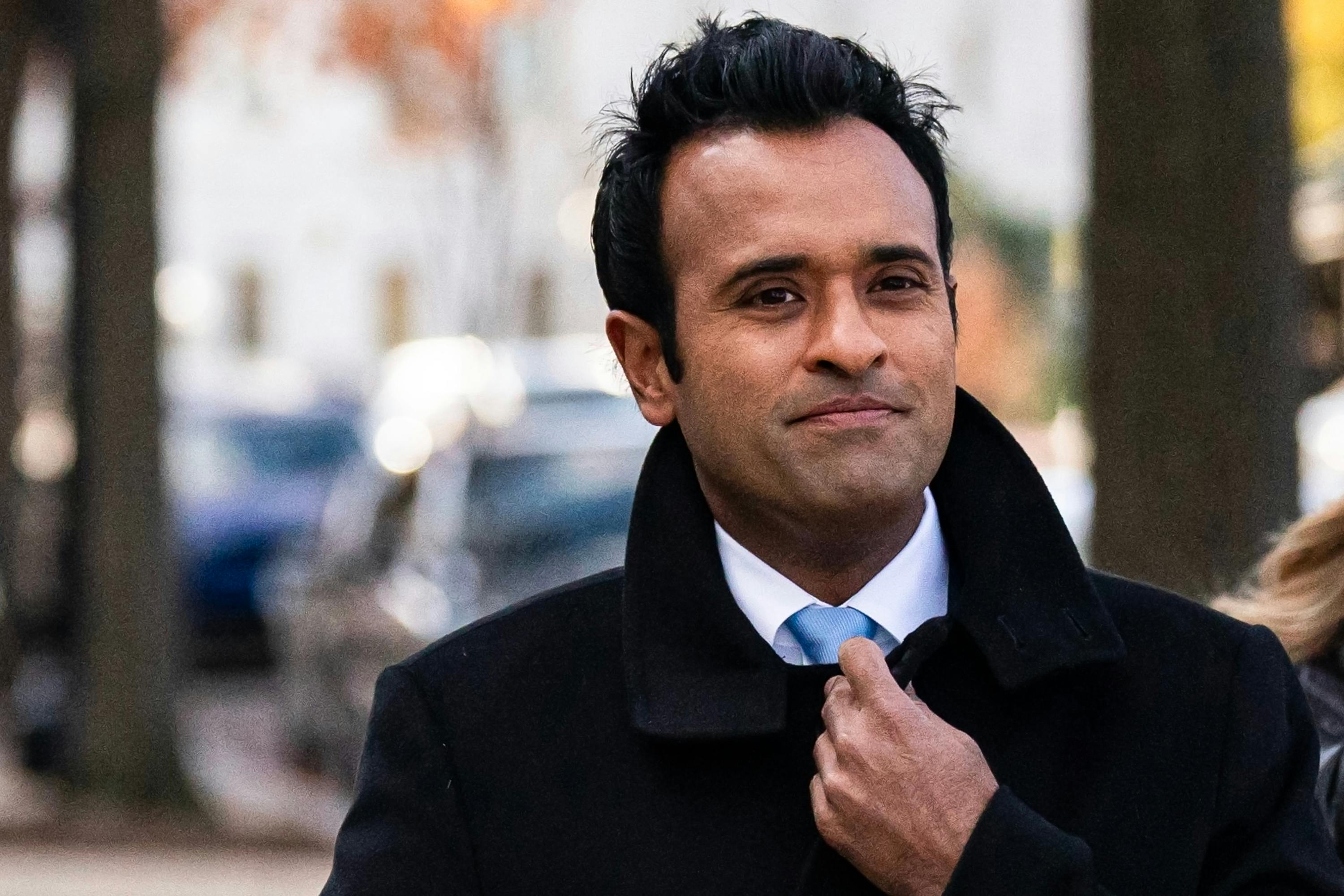 Vivek Ramaswamy holds his coat closed while walking in Washington, D.C.