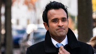 Vivek Ramaswamy holds his coat closed while walking in Washington, D.C.