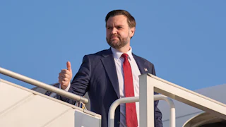 Vice President JD Vance gives a thumbs-up while standing at the top of the embarkment stairs of Air Force Two