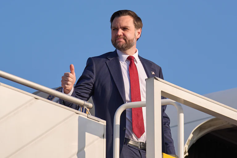 Vice President JD Vance gives a thumbs-up while standing at the top of the embarkment stairs of Air Force Two
