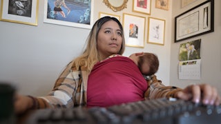 Woman holding baby while working