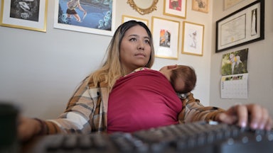 Woman holding baby while working