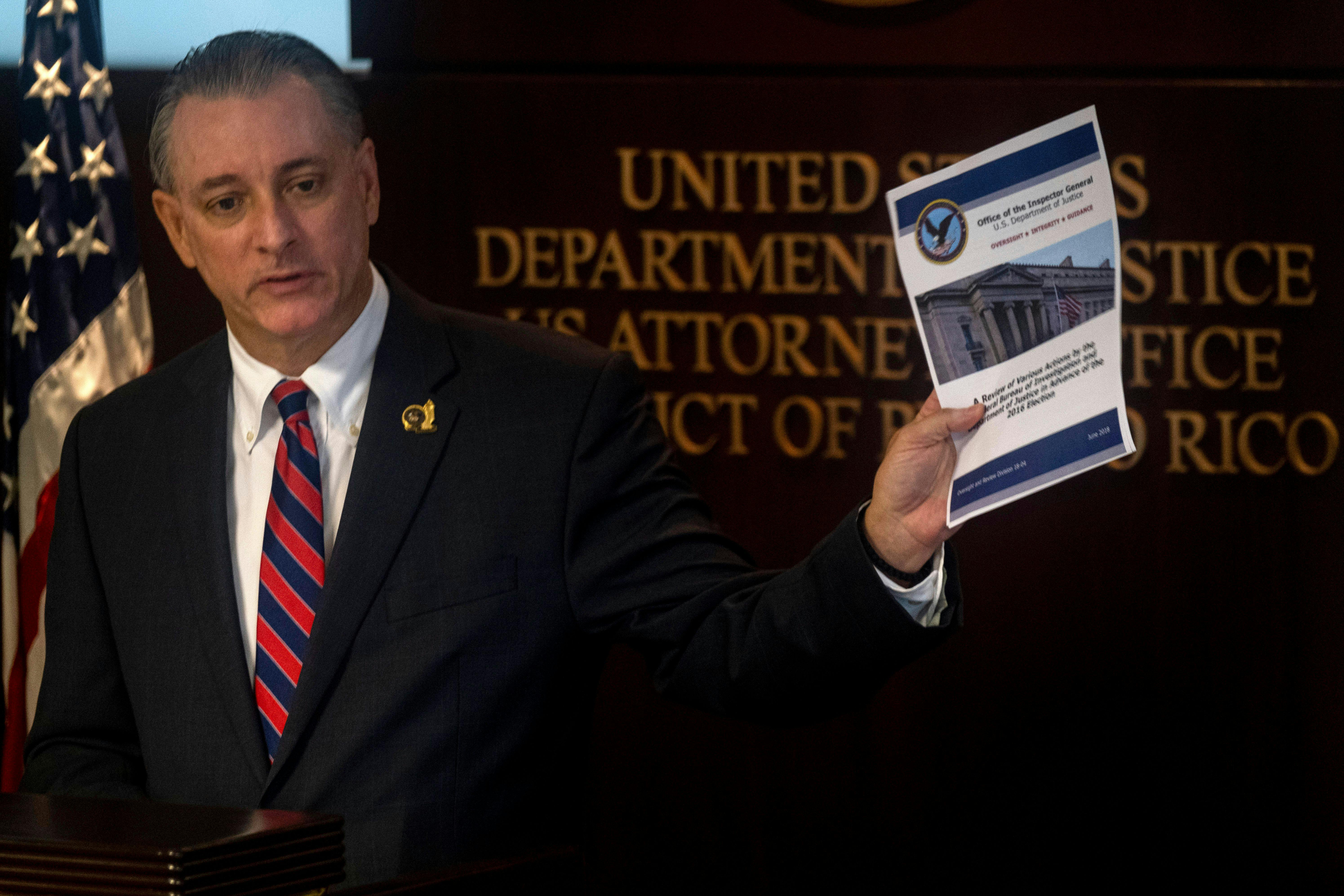 U.S. Attorney for the District of Puerto Rico, W Stephen Muldrow, speaks and holds up a piece of paper in his hand.