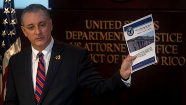 U.S. Attorney for the District of Puerto Rico, W Stephen Muldrow, speaks and holds up a piece of paper in his hand.