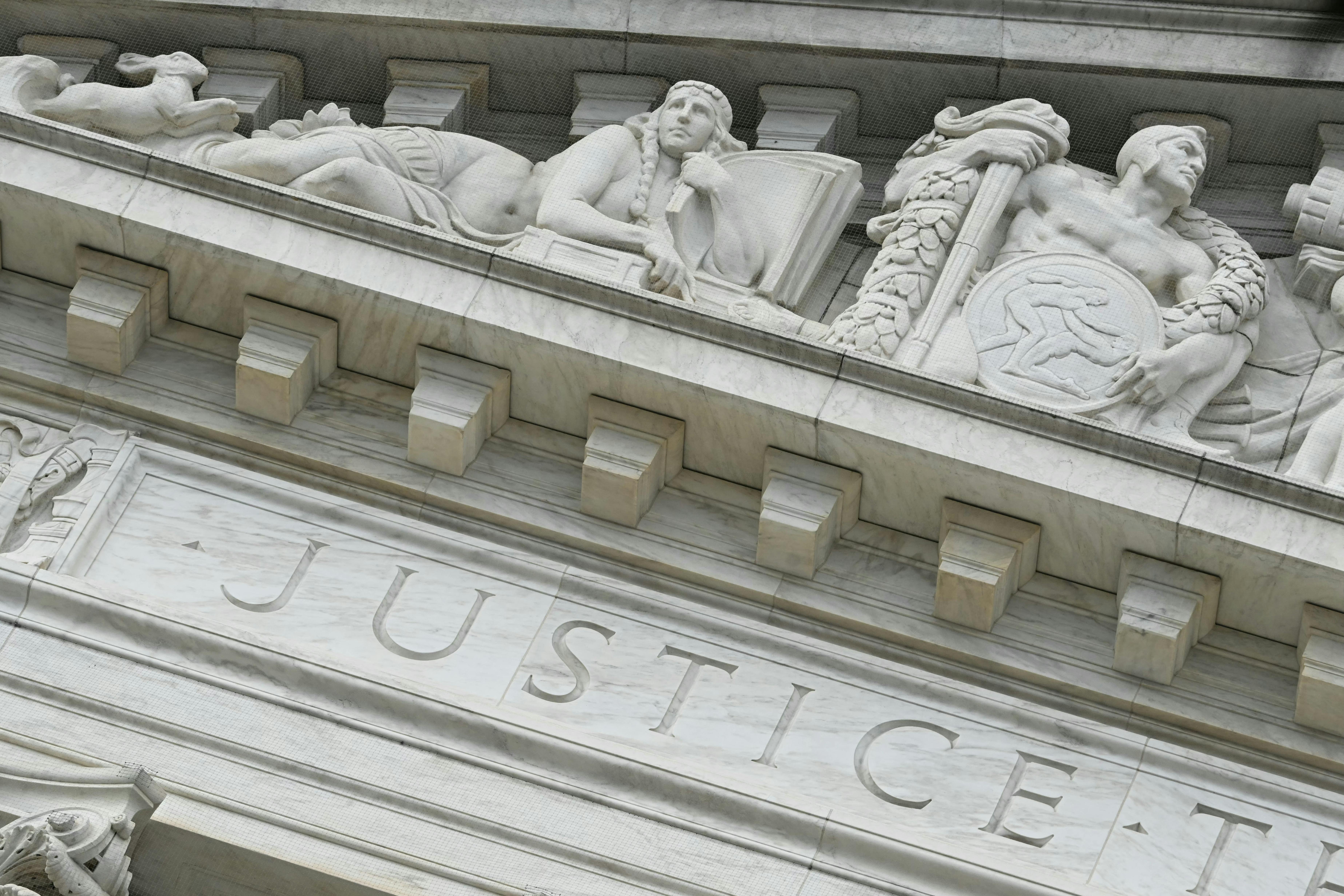 The word “Justice” is seen on the rear side of the U.S. Supreme Court.
