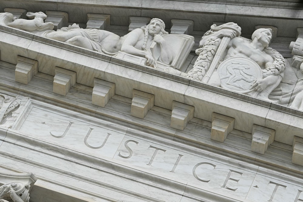 The word “Justice” is seen on the rear side of the U.S. Supreme Court.