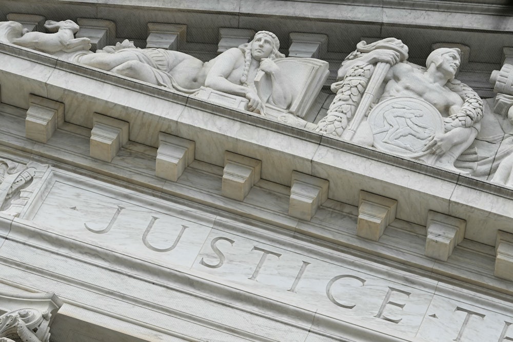 The word “Justice” is seen on the rear side of the U.S. Supreme Court.