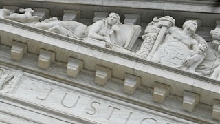 The word “Justice” is seen on the rear side of the U.S. Supreme Court.