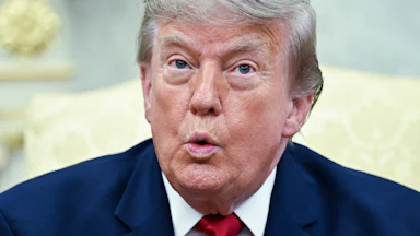 Donald Trump puckers his lips while speaking in the Oval Office.