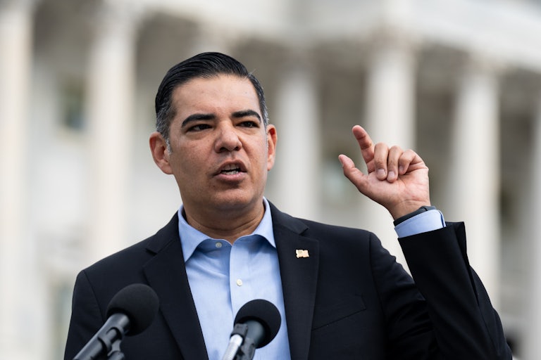 Representative Robert Garcia gestures while speaking into microphones outside the Capitol