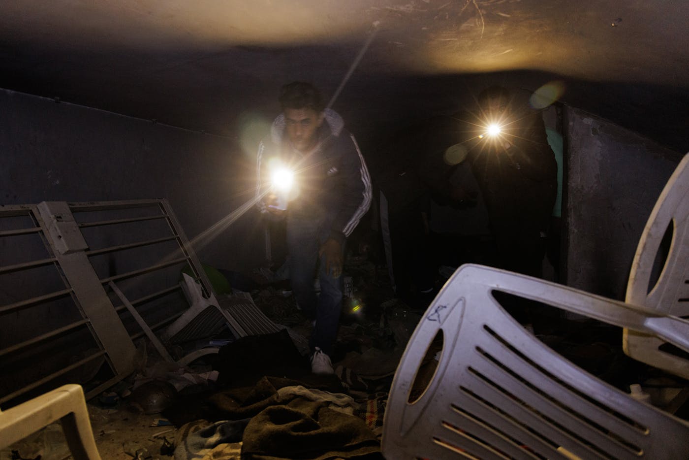 Searchers inspect a room found behind a wall that connects three different cells. Secret rooms such as this one were common in Sednaya Prison; others have been found containing surviving prisoners and dead bodies. 