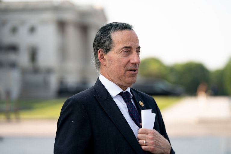 Representative Jamie Raskin holds a rolled up paper to his chest.