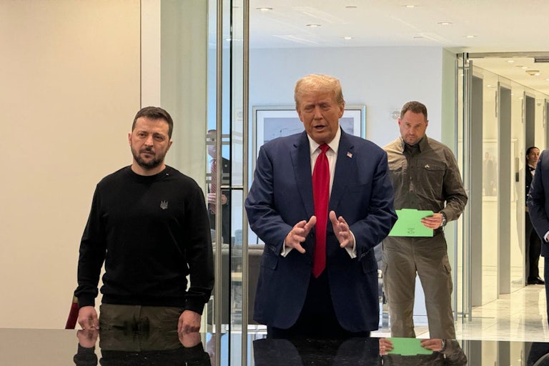 Two men stand behind a table.