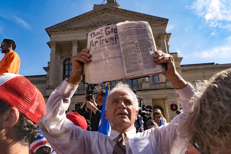 A preacher holds up his Bible while supporters of Donald Trump host a 'Stop the Steal' protest outside of the Georgia State Capital building.